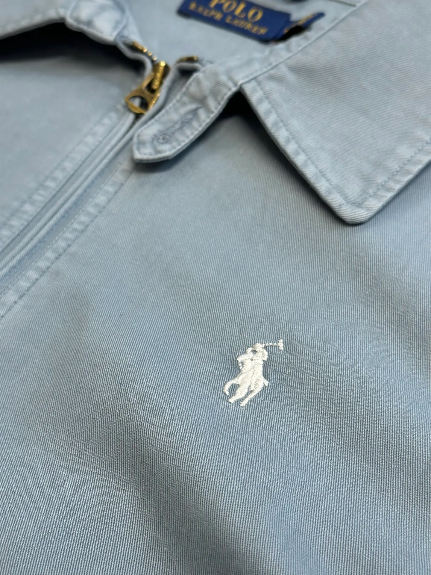 P480 Ralph Lauren embroidered zipper jacket, custom-made cloud velvet blue twill fine cotton, embellished with exquisite white pony logo, fully recognizable. Using imported machine embroidery technology, advanced computer control systems and precision mechanical components are used to achieve the iconic pony embroidery operation with high precision.  The hem is made at one time using a three-needle waist-stretching machine. The machine's special needle position and feeding mechanism are used to sew the elastic band and the fabric together in the same process. The three-needle design is stronger and can evenly distribute pressure to ensure a tight fit between the elastic band and the fabric. Follow the original color series for dyeing and overprinting. Prioritize the original color and fabric material to select special dyes, then heat to the appropriate temperature, perform dip-dyeing, and finally perform color overlay.  size：s m l xl